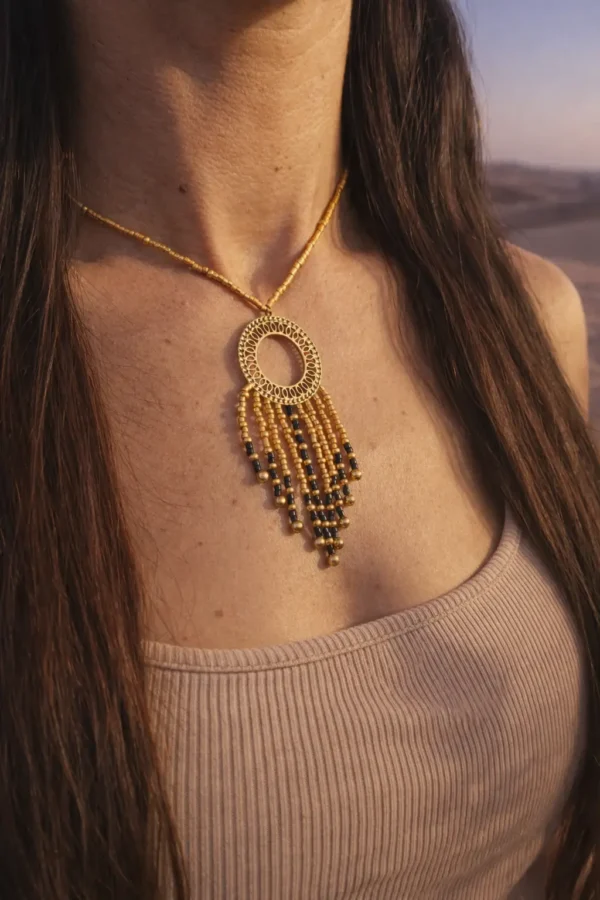 Collier à pendentif Amaziga Sacra et détail sacré Détail collier à pendentif Amaziga Sacra avec cercle doré et perles bleues