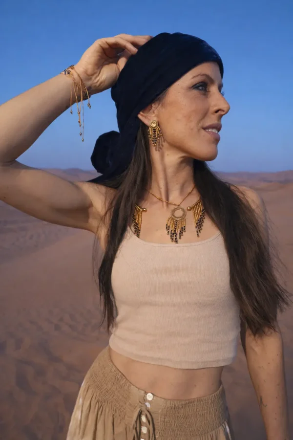 Petites boucles d’oreilles Amaziga Sacra et féminité gardienne Femme portant des petites boucles d’oreilles Amaziga Sacra inspirées de la culture amazighe et du ciel