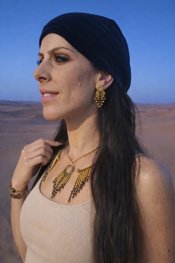 Petites boucles d’oreilles Amaziga Sacra et connexion à l’invisible Petites boucles d’oreilles Amaziga Sacra portées en gros plan avec détails dorés et bleus