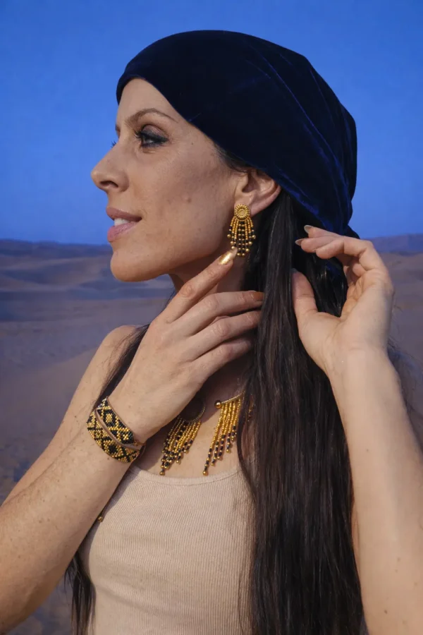 Petites boucles d’oreilles Amaziga Sacra et rituel féminin Petites boucles d’oreilles Amaziga Sacra portées avec bracelet et collier dans un environnement désertique