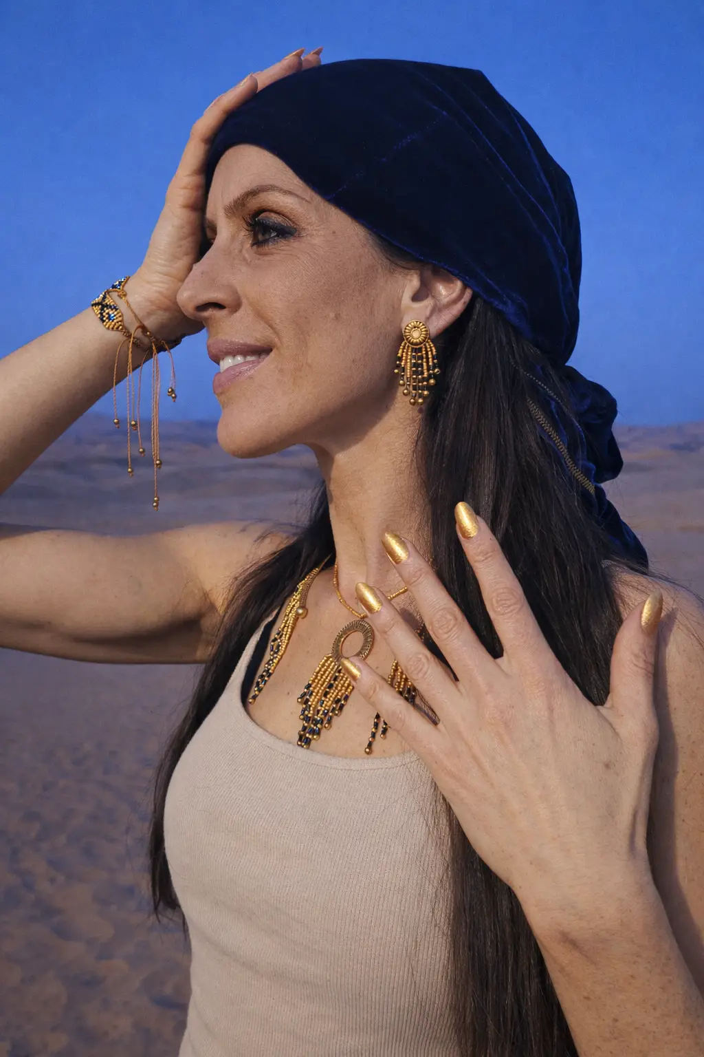 Femme portant les bijoux de la collection Amaziga Sacra de Valdyria, dans un univers bohème sacré aux tons bleu nuit et doré
