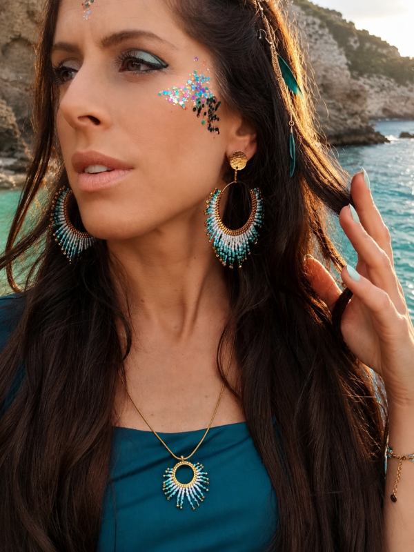 Boucles d’oreilles pendantes Mira Calypsa portées en portrait rapproché avec robe bleue et ambiance poétique Valdyria