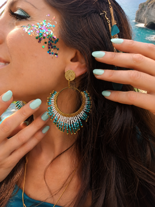 Boucles d’oreilles pendantes Mira Calypsa en détail porté avec maquillage turquoise et bijou artisanal Valdyria