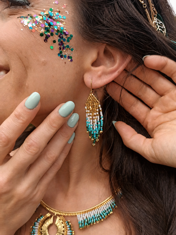 Boucles d’oreilles mini Mira Calypsa en détail portées avec collier assorti dans une ambiance lumineuse et naturelle