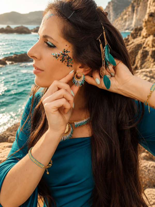 Petites boucles d’oreilles Mira Calypsa et coquillage sacré Petites boucles d’oreilles Mira Calypsa en gros plan avec perles turquoise, or clair et inspiration marine