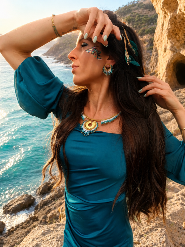 Petites boucles d’oreilles Mira Calypsa et liberté marine Petites boucles d’oreilles Mira Calypsa portées près de la mer turquoise avec bijoux artisanaux et inspiration marine