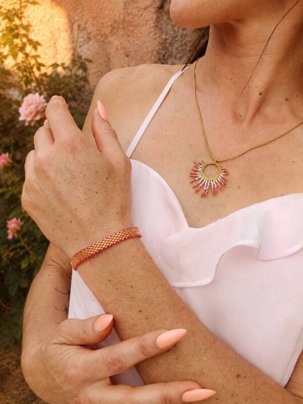 Bracelet Mira Aurora et élégance du matin Bracelet Mira Aurora porté avec collier assorti sur robe blanche, bijou fait main Valdyria dans un jardin ancien fleuri