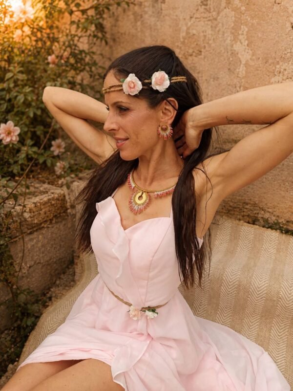 Collier majestueux Mira Aurora porté avec robe rose pâle et fleurs dans les cheveux, bijou fait main Valdyria dans une ambiance florale Collier majestueux Mira Aurora porté avec robe rose pâle et fleurs dans les cheveux, bijou fait main Valdyria dans une ambiance florale