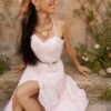Collier majestueux Mira Aurora et douceur du renouveau Collier majestueux Mira Aurora porté assis dans un jardin ancien avec robe claire, bijou artisanal féminin au style Valdyria