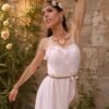 Collier majestueux Mira Aurora et nouveau départ Collier majestueux Mira Aurora porté en pied avec robe blanche et jardin ancien, bijou artisanal Valdyria inspiré du recommencement