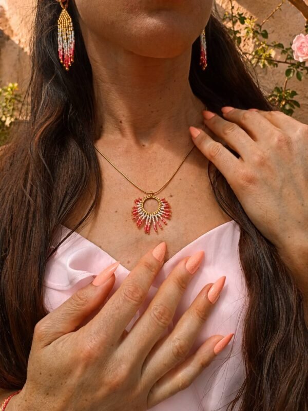 Collier à pendentif Mira Aurora et lumière du recommencement Collier à pendentif Mira Aurora porté en gros plan sur robe rose pâle, bijou artisanal Valdyria dans une ambiance douce et florale