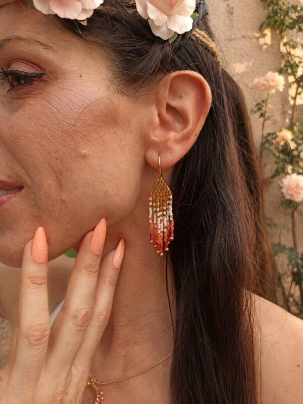 Mini boucles d’oreilles Mira Aurora portées avec main près du visage et fleurs roses, bijou fait main Valdyria au style poétique Mini boucles d’oreilles Mira Aurora portées avec main près du visage et fleurs roses, bijou fait main Valdyria au style poétique