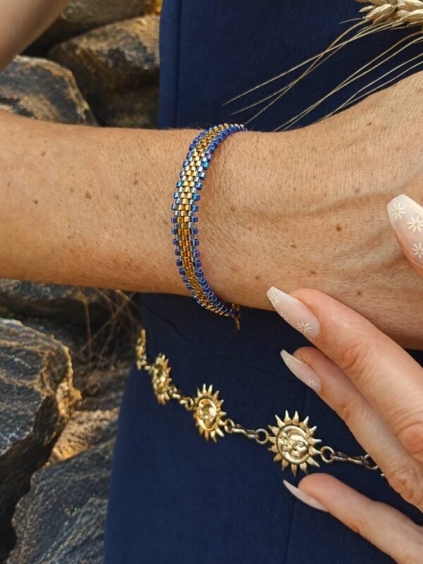 Bracelet Mira Obscura porté au poignet dans un décor minéral, bijou artisanal Valdyria en perles Miyuki bleu nuit et or