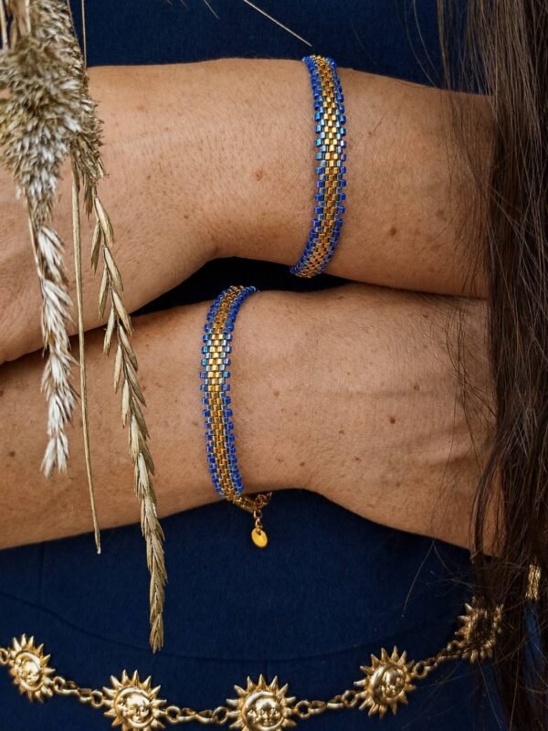 Bracelet Mira Obscura porté près du visage, création artisanale française en perles bleu nuit et or