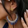 Boucles d’oreilles pendantes Mira Obscura et mystère nocturne Boucles d’oreilles pendantes Mira Obscura portées dans un décor minéral, bijou femme bleu nuit et or au style artisanal Valdyria