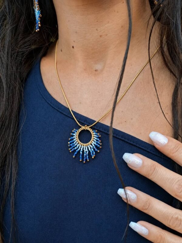 Collier à pendentif Mira Obscura et artisanat français Collier à pendentif Mira Obscura porté de profil avec tenue asymétrique bleu marine, création artisanale française