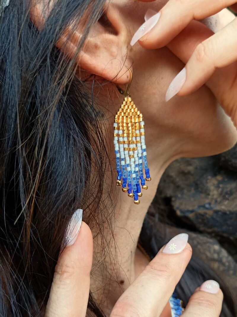 Mini boucles d’oreilles Mira Obscura portées près de l’oreille avec franges bleues et dorées, bijou fait main en Alsace