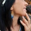 Mini boucles d’oreilles Mira Obscura portées avec parure assortie dans un décor minéral, bijou femme élégant bleu nuit