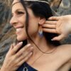 Mini boucles d’oreilles Mira Obscura portées avec robe asymétrique bleu nuit et pendentif, style bohème haut de gamme