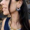 Petites boucles d’oreilles Mira Obscura portées près du visage avec parure assortie et style femme mystique