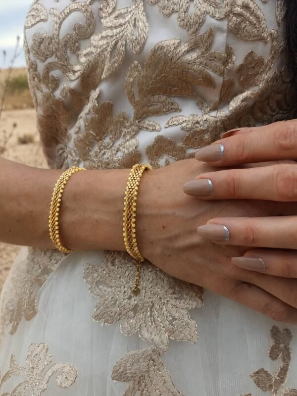 Bracelet Mira Helia porté au poignet en extérieur, bijou talisman Valdyria en perles Miyuki dorées et nuances or miel