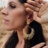 Boucles d’oreilles pendantes Mira Helia et artisanat français Boucles d’oreilles pendantes Mira Helia portées près du visage, création artisanale française aux nuances or miel et ambre