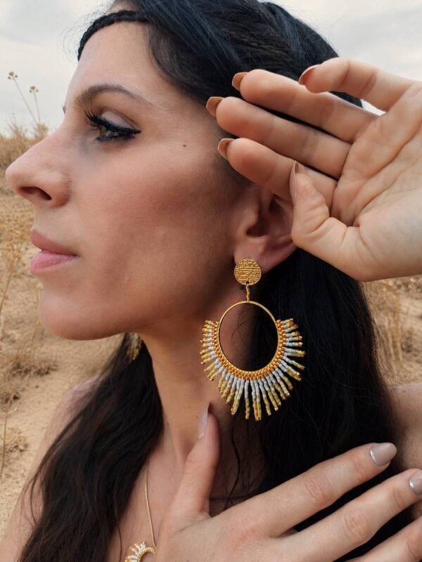Boucles d’oreilles pendantes Mira Helia et artisanat français Boucles d’oreilles pendantes Mira Helia portées près du visage, création artisanale française aux nuances or miel et ambre