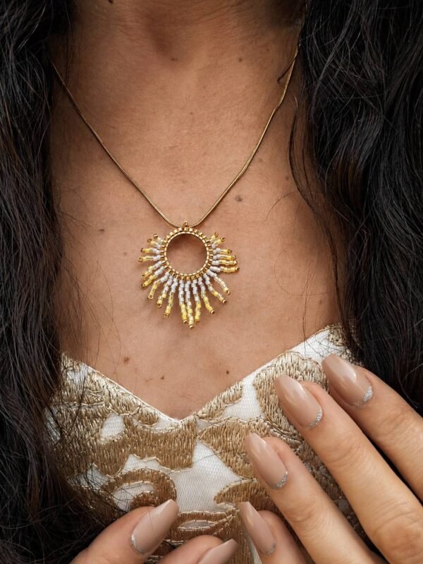 Collier à pendentif Mira Helia et bijou talisman Collier à pendentif Mira Helia porté en extérieur, bijou talisman Valdyria en perles Miyuki dorées et ambre solaire