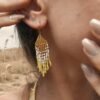 Mini boucles d’oreilles Mira Helia portées près de l’oreille avec franges dorées, bijou fait main inspiré par l’ambre solaire