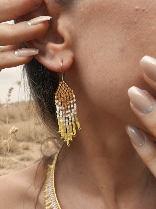 Mini boucles d’oreilles Mira Helia portées près de l’oreille avec franges dorées, bijou fait main inspiré par l’ambre solaire