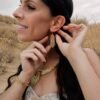 Mini boucles d’oreilles Mira Helia portées de profil dans un décor naturel, bijou femme doré fait main Valdyria