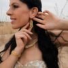 Mini boucles d’oreilles Mira Helia portées près du visage, bijou artisanal doré inspiré des Héliades et de la résilience