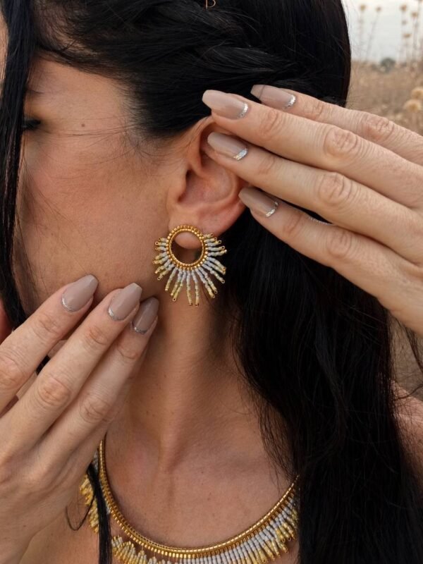 Petites boucles d’oreilles Mira Helia portées en gros plan, bijou artisanal Valdyria en perles Miyuki or miel et ambre solaire