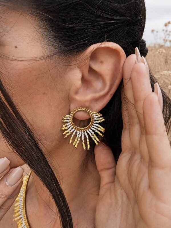 Petites boucles d’oreilles Mira Helia portées près du visage avec détails dorés, bijou fait main inspiré par la résilience