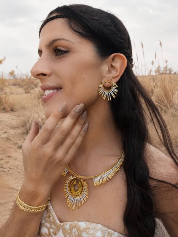 Petites boucles d’oreilles Mira Helia portées avec collier assorti dans un décor naturel, création artisanale française dorée