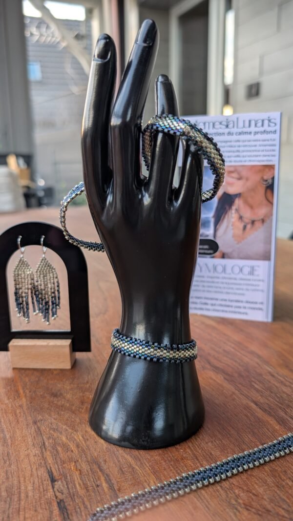 Bracelet Artemesia Lunaris clair et douceur lunaire Bracelet Artemesia Lunaris clair présenté sur support noir, bijou artisanal Valdyria en perles Miyuki bleu clair, bleu nuit et argent