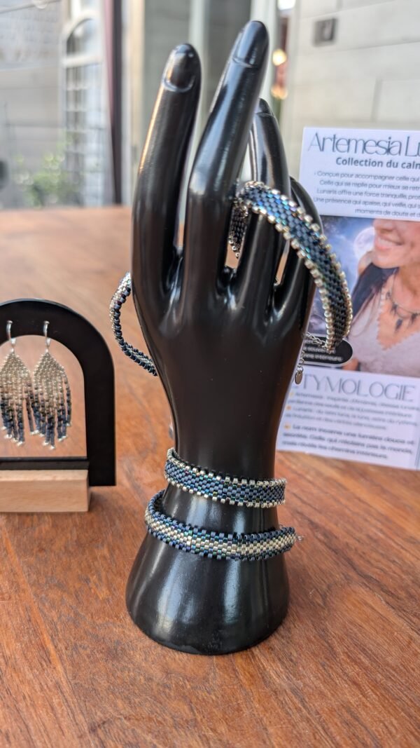 Bracelet Artemesia Lunaris foncé porté sur présentoir, bijou éthique Valdyria au design conscient et inspiration lunaire