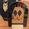 Mini boucles d’oreilles Galilya Cleo Ébène et bijou talisman Mini boucles d’oreilles Galilya Cleo Ébène présentées sur support noir, bijou talisman aux motifs géométriques noir et bronze
