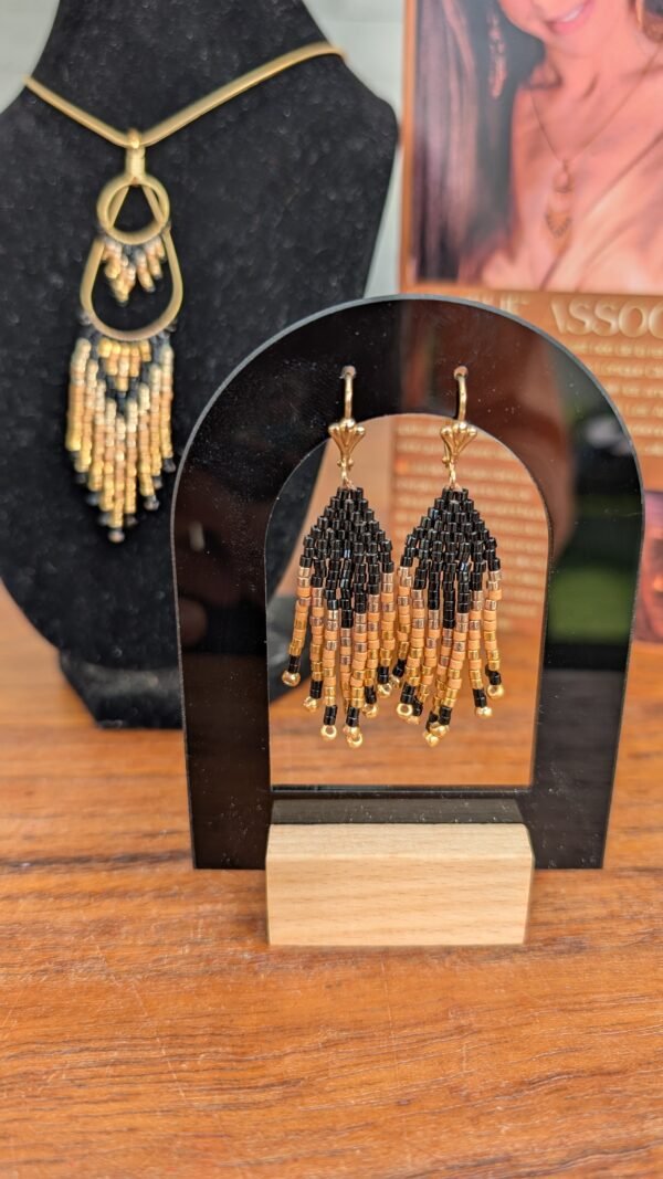 Mini boucles d’oreilles Galilya Cleo Ébène et bijou talisman Mini boucles d’oreilles Galilya Cleo Ébène présentées sur support noir, bijou talisman aux motifs géométriques noir et bronze