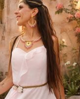 Collier majestueux Mira Aurora porté en portrait avec robe rose pâle et jardin fleuri, bijou fait main en perles Miyuki