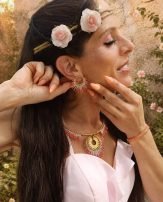 Petites boucles d’oreilles Mira Aurora portées en portrait fleuri avec robe rose, bijoux coordonnés et ambiance poétique