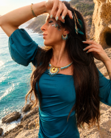 Petites boucles d’oreilles Mira Calypsa portées près de la mer turquoise avec bijoux artisanaux et inspiration marine