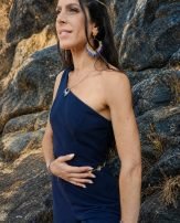 Boucles d’oreilles pendantes Mira Obscura en gros plan sur peau, bijou artisanal haut de gamme inspiré par la nuit sacrée